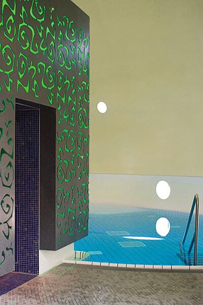 Abgedichtetes Thermalbad mit grünen Wandornamenten und Fliesenboden