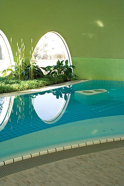 Abgedichtetes Schwimmbad mit ovalen Fenstern und grüner Wand