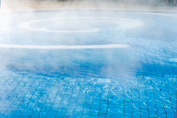 Thermalbad mit Dampf über geschwungener Beckenkontur