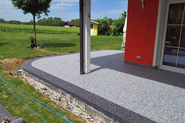 Hellgrauer Steinteppich auf geschwungener Terrasse