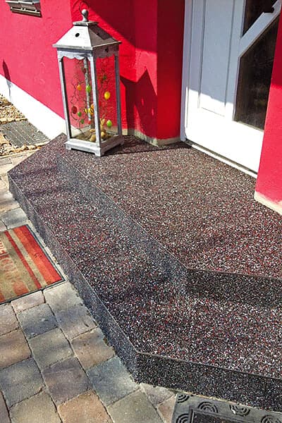 Rot-bunter Steinteppich auf Hauseingangstreppe