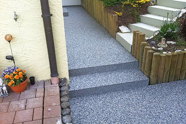 Grauer Steinteppich auf Außentreppe und Gehweg