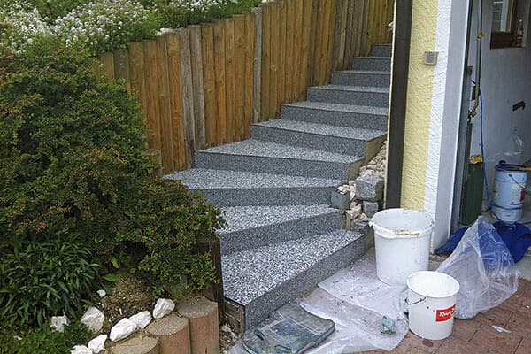 Einbau eines grauen Steinteppichs auf Gartentreppe